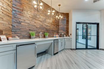 Clubhouse kitchen with wood accent wall and pendant lighting